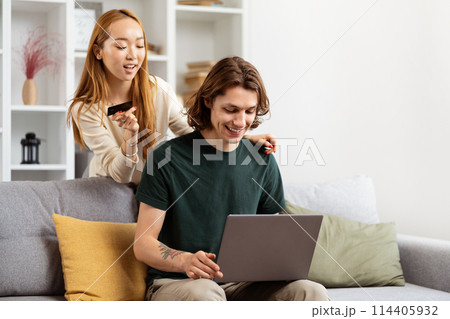 Young Couple Enjoying Online Shopping In Living Room Young Couple Enjoying Online Shopping In Living Room 114405932