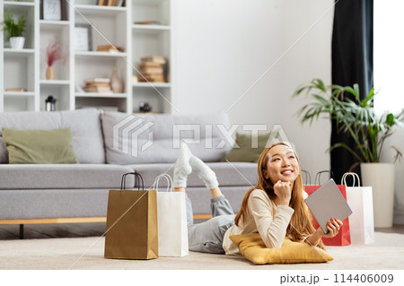 Young Woman Relaxing With Shopping Bags In Modern Living Room 114406009