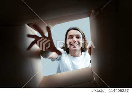Happy Young Man Unpacking Boxes Happy Young Man Unpacking Boxes 114406227