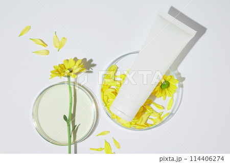 Creative advertising photo for skincare or health care products made from organic ingredient like calendula flower with blank label tube for branding. Copy space, top view Creative advertising photo for skincare or health care products made from organic ingredient like calendula flower with blank label tube for branding. Copy space, top view 114406274