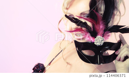 Woman middle aged holds carnival mask. 114406371
