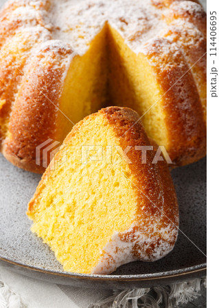 Citrus Orange Pound Cake sprinkled with powdered sugar close-up on a plate. Vertical 114406695