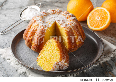 Meskouta is a simple, soft, fluffy orange cake close-up on a plate. Horizontal 114406696