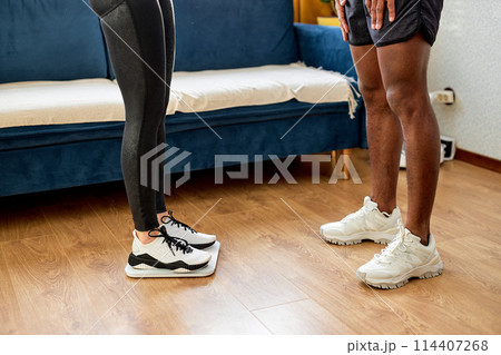 black man and woman checking weight after sport workout, unrecognizable people black man and woman checking weight after sport workout, unrecognizable people 114407268