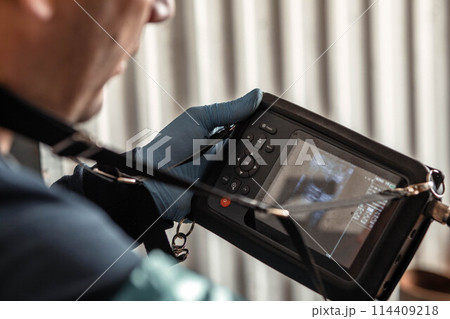 veterinarian focused on an ultrasound screen, using sophisticated diagnostic tools to assess the health of livestock veterinarian focused on an ultrasound screen, using sophisticated diagnostic tools to assess the health of livestock 114409218