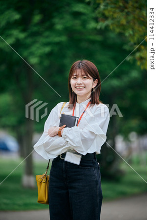 手帳を持って微笑む若い女性 手帳を持って微笑む若い女性 114412334