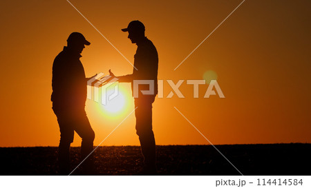 Firm handshake between two men at sunset Firm handshake between two men at sunset 114414584