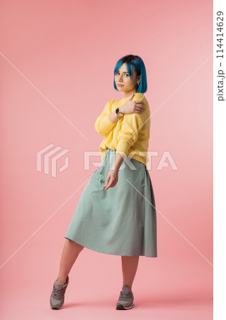 modest girl holding her shoulder and looking at the camera 114414629