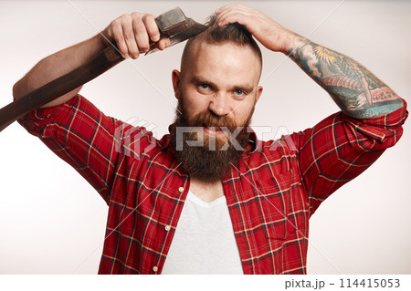 bearded man shaving with an axe on black background bearded man shaving with an axe on black background 114415053