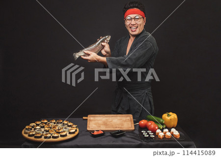 attractive smilingman holding a big fish and posing to the camera 114415089