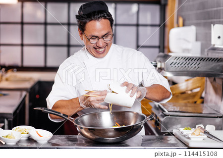 gorgeous asian man in white uniform working in the kithcen room gorgeous asian man in white uniform working in the kithcen room 114415108