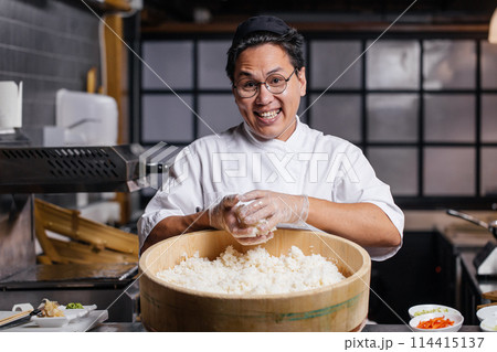 positive guy in uniform holding rice and posing to the camera 114415137