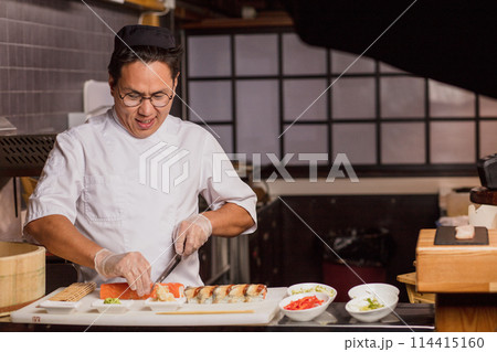 talented chef tryi g to cut roll neatly talented chef tryi g to cut roll neatly 114415160