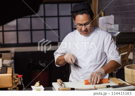 good looking positive famele chef is going to cut the roll good looking positive famele chef is going to cut the roll 114415163