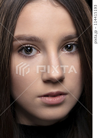 Close-up face of a beautiful young brunette girl. 114415193