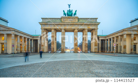 Twilight descends on Brandenburg Gate, with soft lighting illuminating the historic arch and the Quadriga statue atop. Berlin, Germany 114415527