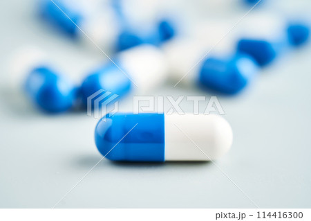 Blue and white capsules on a blue background. 114416300