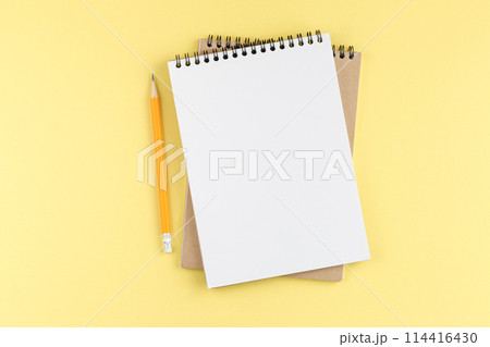Spiral notebook with orange pencil. Top view. Spiral notebook with orange pencil. Top view. 114416430