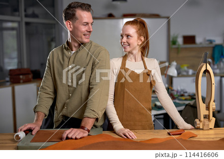 smiling charming happy loving couple look at each other while working 114416606