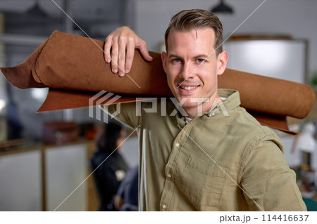 cheerful happy handsome master has idea for new leather products. 114416637