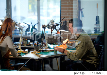 young active craftsman and craftswoman working in the workshop 114416809