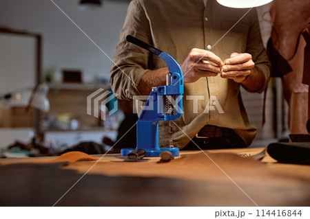 young skilled artisan decorating designing belt at workplace 114416844