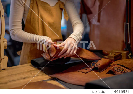 young skilled artisan restoes old bad leather 114416921