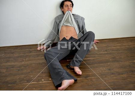 drunk alcoholic mad man sitting on floor in living room. drunk alcoholic mad man sitting on floor in living room. 114417100
