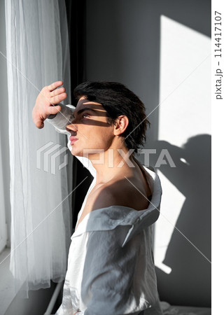 Young man closing his eyes under the sun Young man closing his eyes under the sun 114417107