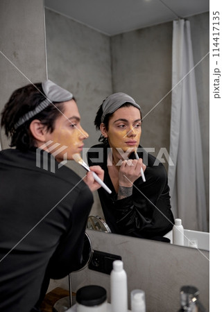 glamour man in stylish black robe and eyemask on his head applying clay mask 114417135