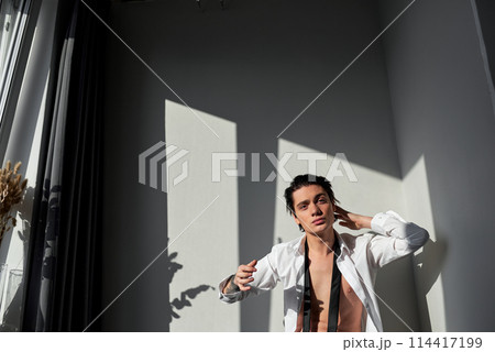 young handsome man takes care of his hair young handsome man takes care of his hair 114417199