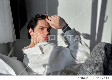 unhappy drunk guy looks at camera 114417313