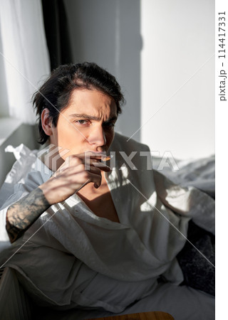 serious exhausted man is after a hangover in the morning 114417331