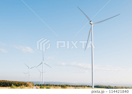 Nature meets technology, turbines on a mountain farm harness wind power for clean electricity. A modern windmill industry supporting sustainable development. Nature meets technology, turbines on a mountain farm harness wind power for clean electricity. A modern windmill industry supporting sustainable development. 114421840