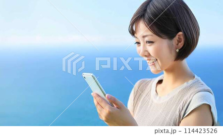 海を背景にスマホをする女性 海を背景にスマホをする女性 114423526