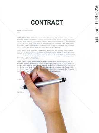Closeup woman hand holding a pen signing her name on a CONTRACT document. Top View Closeup woman hand holding a pen signing her name on a CONTRACT document. Top View 114424256