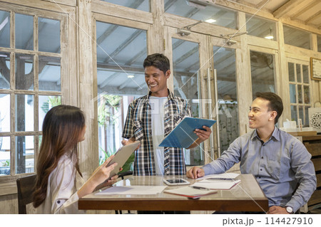 Happy diversity business people smile during a planning, coaching, brainstorming for project meeting in a startup company. Happy diversity business people smile during a planning, coaching, brainstorming for project meeting in a startup company. 114427910
