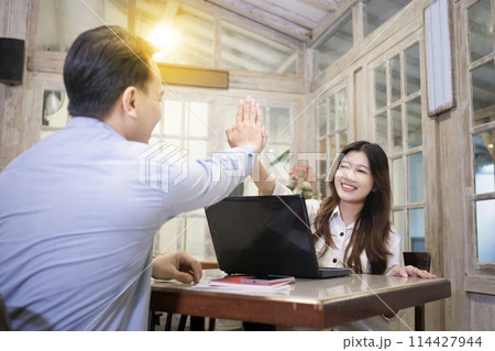 Portrait of multiethnic business colleagues high five during a meeting 114427944