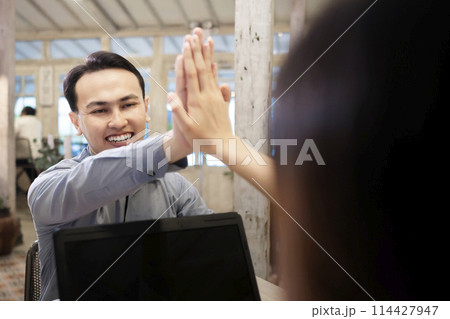 Portrait of multiethnic business colleagues high five during a meeting 114427947