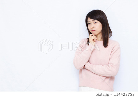 真剣に悩んでいる女性 114428758