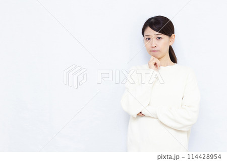 真剣に悩んでいる女性 114428954