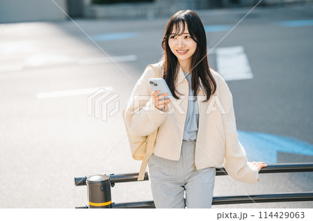 道端でスマホを持って考える女性 114429063