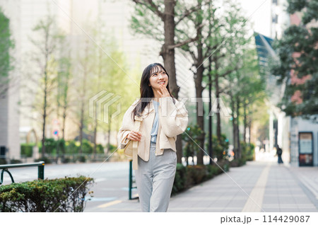 街を楽しそうに歩く女性 114429087