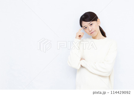 真剣に悩んでいる女性 114429092