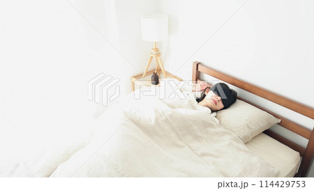 明るい部屋でアイマスクを付けて寝る女性 114429753