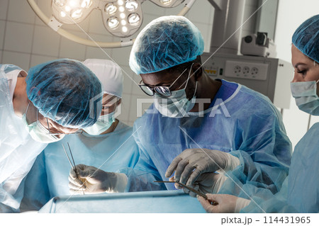 group of successful doctors looking at the patient 114431965