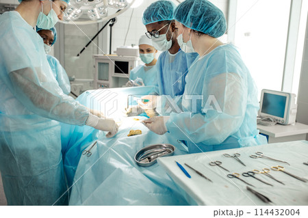 doctors in special uniform smearing antibiotic cream on the wound 114432004