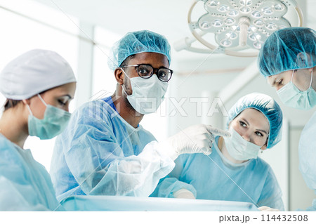 puzzled scared handsome afro doctor pointing at somewhere puzzled scared handsome afro doctor pointing at somewhere 114432508