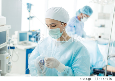 attractive nurse preparing oxygen mask for a patient attractive nurse preparing oxygen mask for a patient 114432510