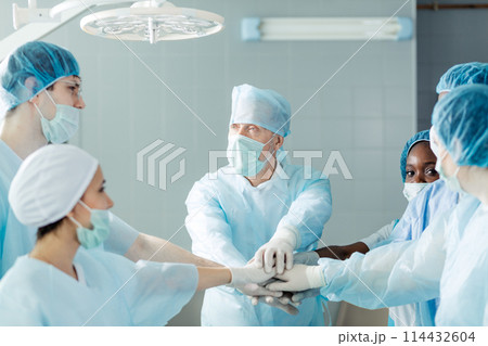 united friendly surgeons putting hands together on the top of each other 114432604